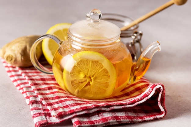 Hot Tea with Lemon in Teapot on Linen Napkin Glass Teapot with Healthy Drink for Cold and Flu