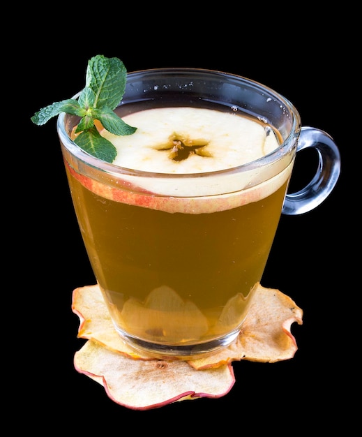 Hot tea with sea buckthorn and apple In a glass cup on a dark background