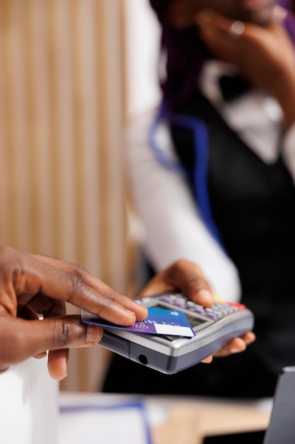 Photo hotel guest paying for room with card