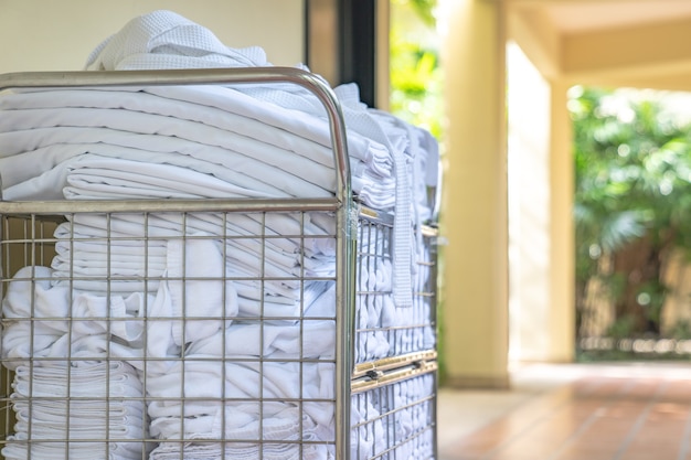 Hotel maid trolley parking front of the room with clean towel and bathrobes ready to change and make up the room.