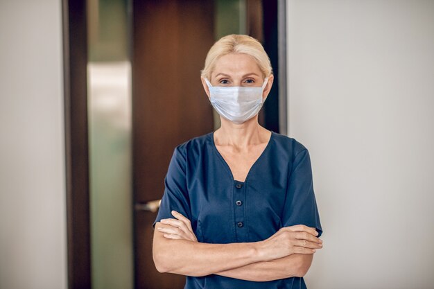 Hotel personnelService woman in a protective mask standing in the room