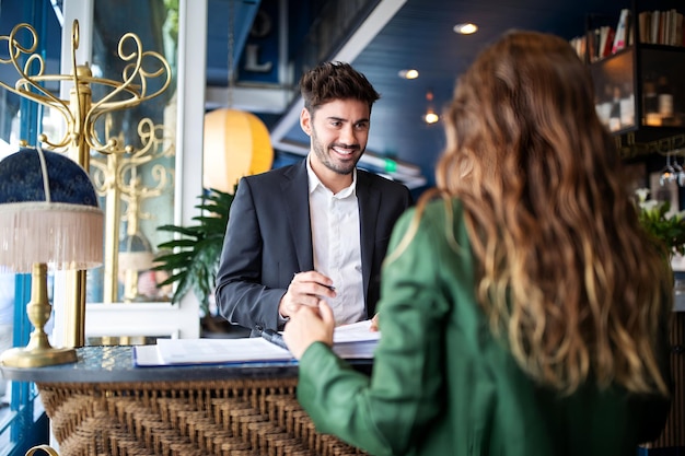 Photo hotel receptionist assisting guest for checking in