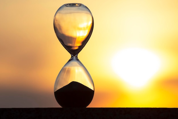 Hourglass on the background of a sunset. The value of time in life. An eternity.