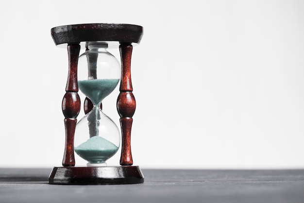 Hourglass on grey desk showing the last second or last minute or time out