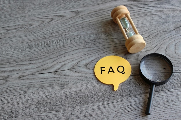 Hourglass magnifying glass and speech bubble with text FAQ Frequently asked question concept