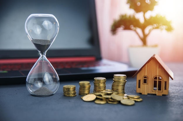 Hourglass with coins and house model