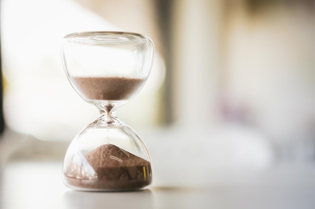 Hourglass on a wooden table convey memories with the passing of time