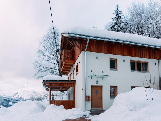 House architecture and snow winter landscape at Bad Goisern village near Hallstatt, in Upper Austria. Townhouse real estate and residential building.