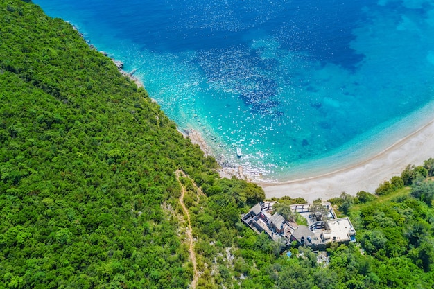 House by the sea surrounded by green forest top view