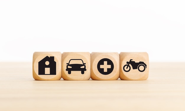 House, car, health and bike icons on wooden blocks Types of insurance concept