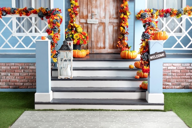 House entrance staircase decorated for autumn holidays, fall flowers and pumpkins