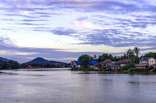 House is located by the river. And the house is old, and is made of wood.