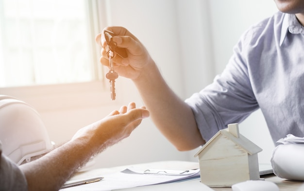 House key given by salesman, concept in  insurance broker agent's hand protection