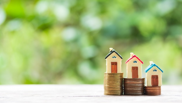 House model and coin money on table for finance and banking concept.