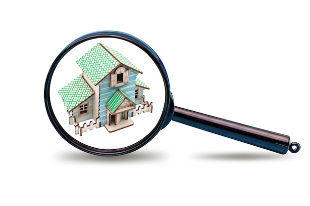 House model under a magnifying glass on a white isolated background. Concept for real estate advertising. Buying, selling renting a house. Mortgage. Copy space.