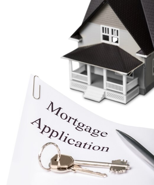 House model and Mortgage Application document with keys on white table