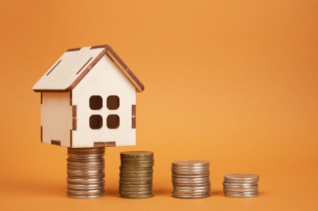 house model and towers of coins on a brown background