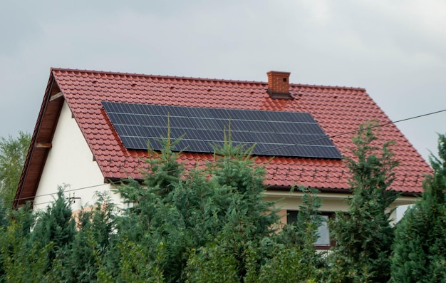 House roof with photovoltaic modules. Historic farm house with modern solar panels on roof and wall