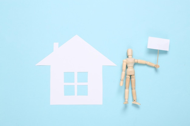 House for sale Paper house and puppet with blank sign on blue background