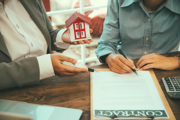 House signers signing signature loan document to home ownership with real estate agents ownership. Mortgage and real estate property investment, home insurance