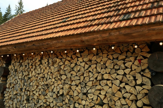 House with dry chopped firewood logs in a pile