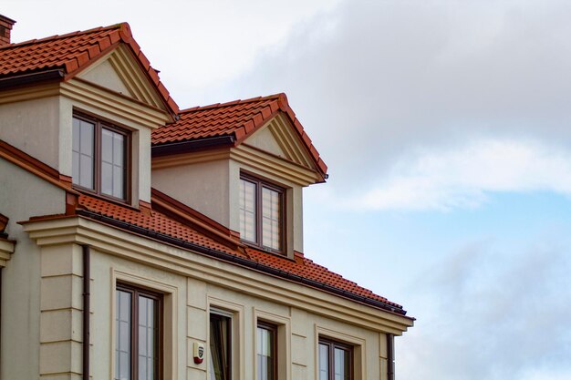 Photo a house with a red roof and a blue sky in the background