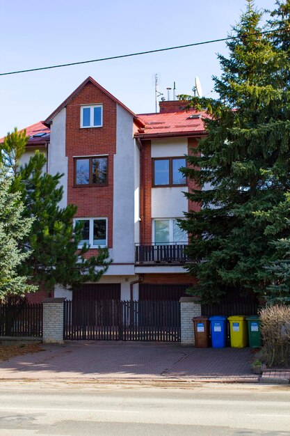 A house with a red roof and a windows and green trees near