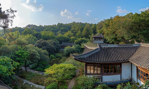 Photo a house with a shingled roof and a blue house with a mountain behind it