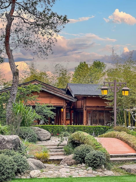 A house with a stone walkway and a tree in front of it