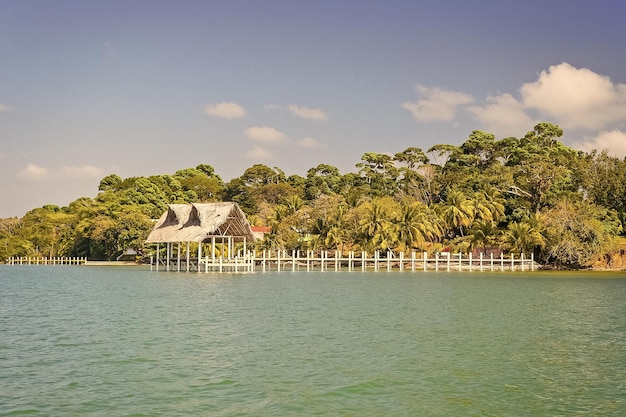 House of wood and grass on tropical beach in guatemala santo tomas Hut on sea shore on sunny blue sky Summer vacation on island Wanderlust adventure and discovery