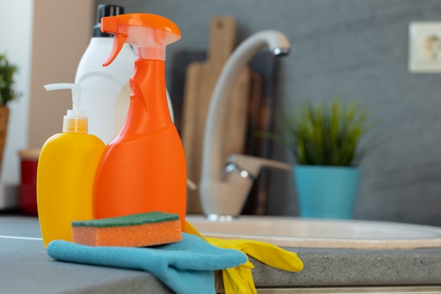 Household chemicals product bottles standing near the kitchen sink