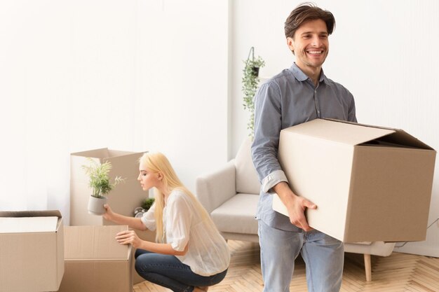 Photo household move happy couple packing stuff in boxes