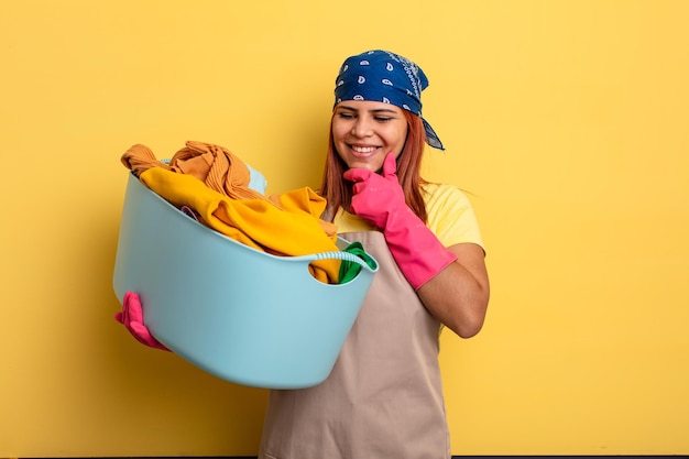 Photo housekeeper smiling with a happy confident expression with hand on chin washing clothes concept