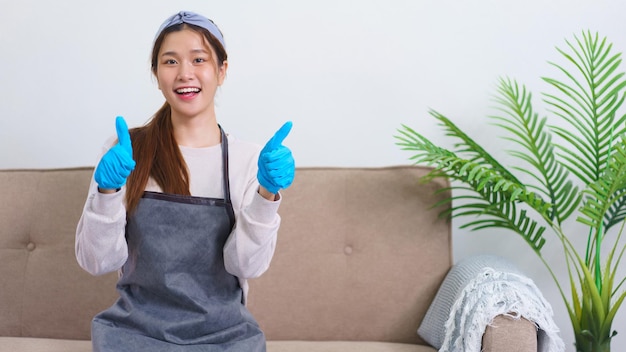 Housekeeping concept Housemaid smile and doing thumbs up gesture after successfully cleaning house