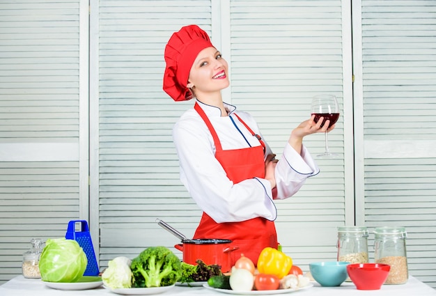 Housekeeping and culinary. Housewife prepare meal with wine. Housewife daily routine. Girl adorable chef. Housewife cooking and drink wine. Enjoy easy ideas for dinner. Woman enjoy cooking food.