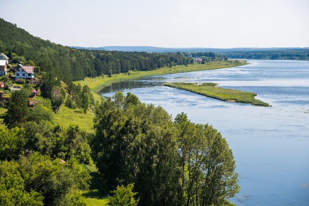 Houses along a beautiful wide river in the middle of the forest