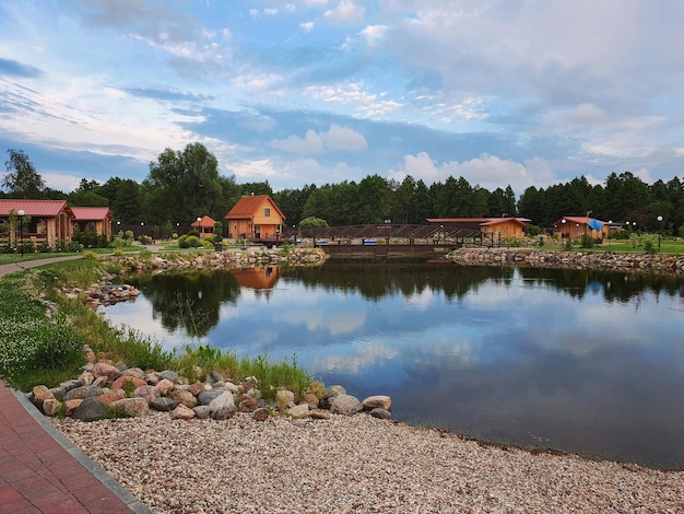 Photo houses by lake and buildings against sky