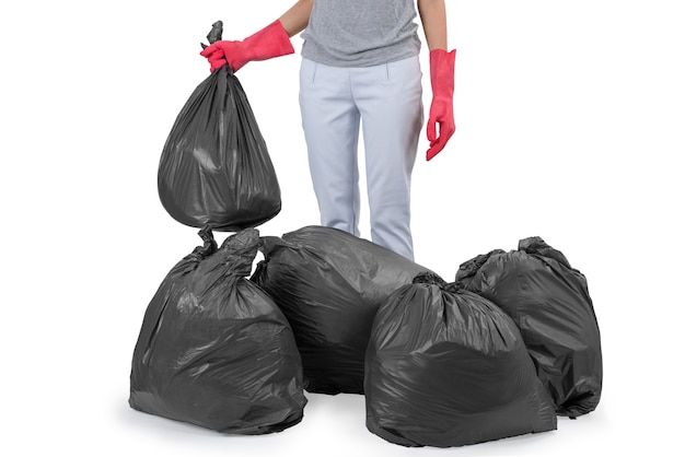 Housewife standing among garbage bags isolated on white