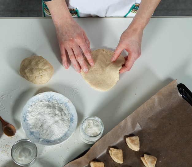 Housewife woman prepares homemade biscuits in the kitchen