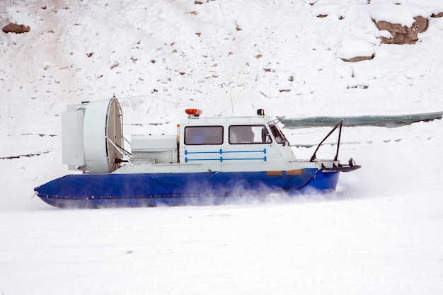 A hovercraft glides over the surface of a frozen river Winter tourism