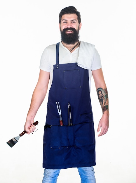 How choose meat for steak. Professional barbecue utensil. Bearded hipster wear apron for barbecue. Roasting and grilling food. Tips cooking meat. Tools for roasting meat outdoors. Picnic and barbecue.