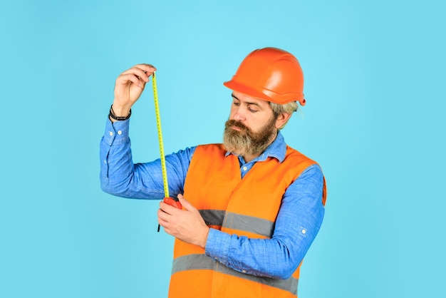 How long is it Man in uniform works on the production Industrial modern technology builder with tape Yellow colored measuring tape bearded man in hardhat brutal hipster worker use tape measure