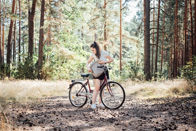 How to pack for bike ride bicycle touring checklist young woman with backpack riding bike in pine