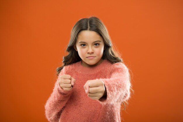 How teach kids to defend themselves. Self defense strategies kids can use against bullies. Girl hold fists ready attack or defend. Girl child cute but strong. Self defense for kids. Defend Innocence.