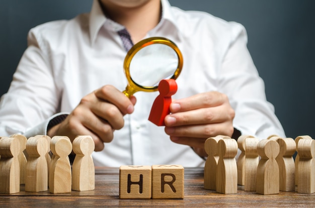 The HR examines a candidate red figure Recruiting new workers headhunters Human resources