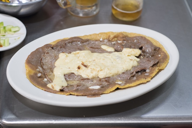 Huarache traditional Mexican food with beef and cheese.