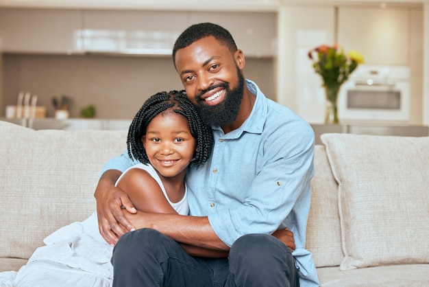 Hug happy and portrait of a girl with her father on the living room sofa to relax together in a house Family love and African dad hugging his child with care and a smile on the couch in their home