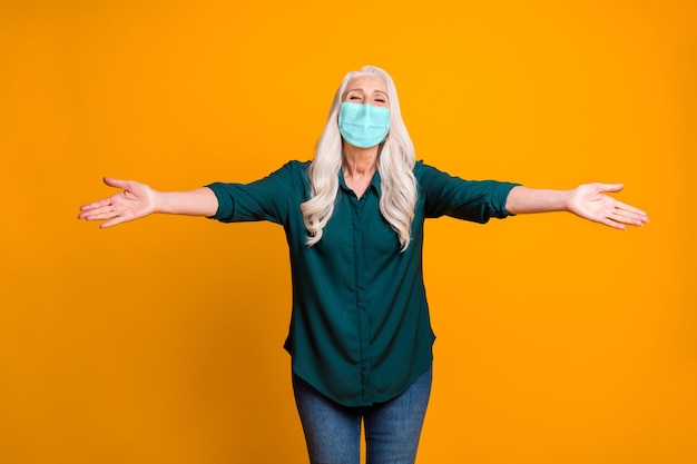 Hug me! Photo of grandma spread open arms wear mask green shirt jeans isolated vivid yellow color background