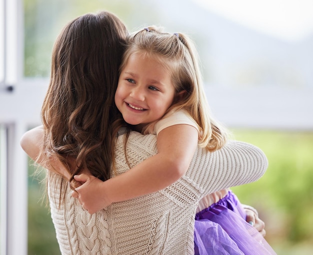 Hug mom and girl child in home for love care or bonding together with single parent or wellness Connection safety and happy mother in kitchen with support security and smile with kid or family