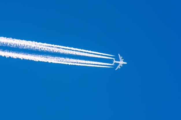 Huge airplane big four engines aviation airport contrail clouds.